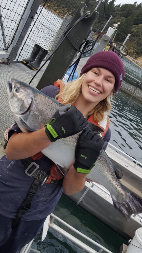 Ally Perkins on a seafarm with a King salmon
